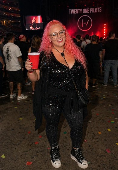 Woman in sparkly black one piece full legged pant outfit at concert