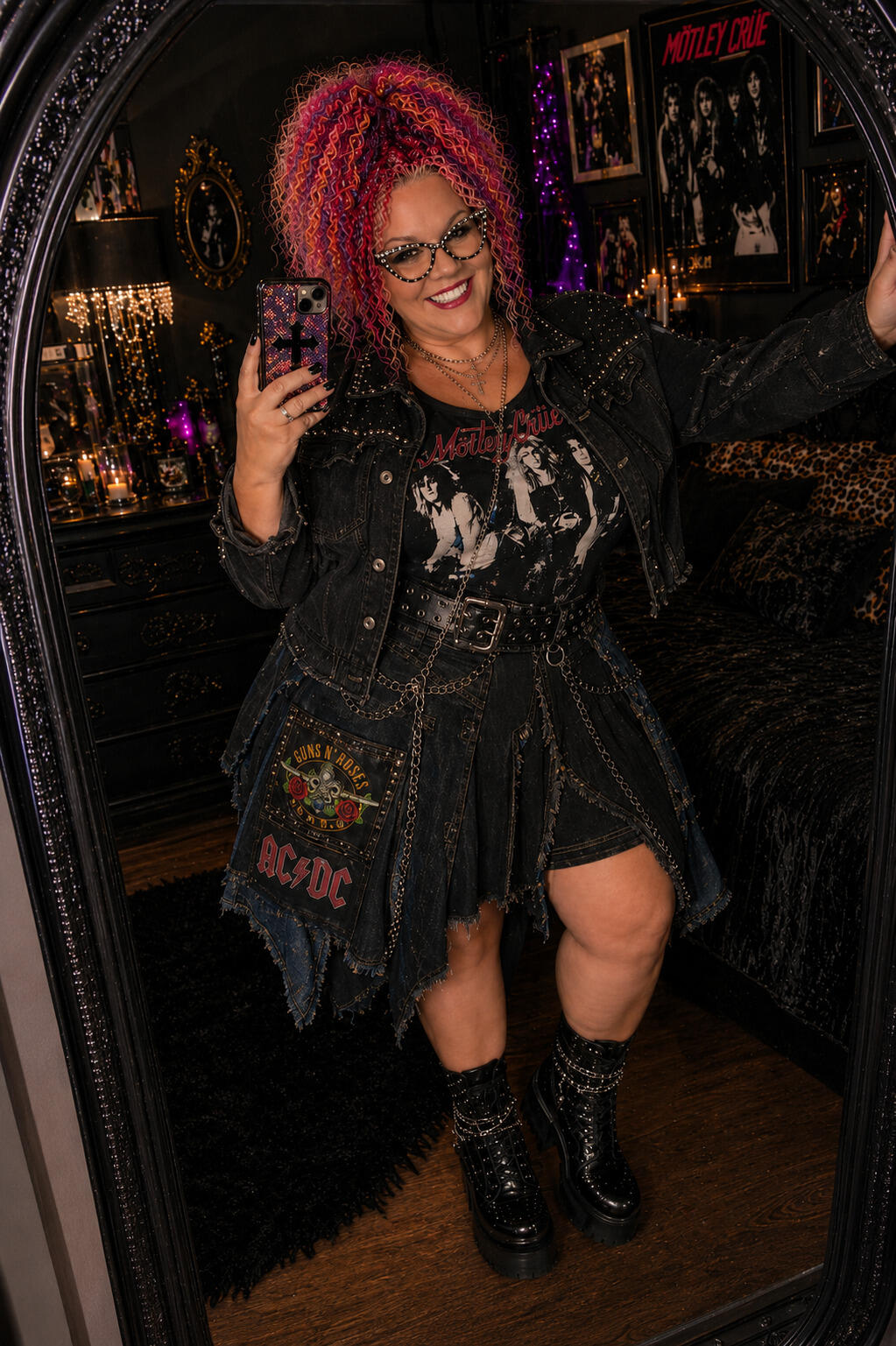 Woman posing in front of a mirror in a denim and patchwork band tee outfit.