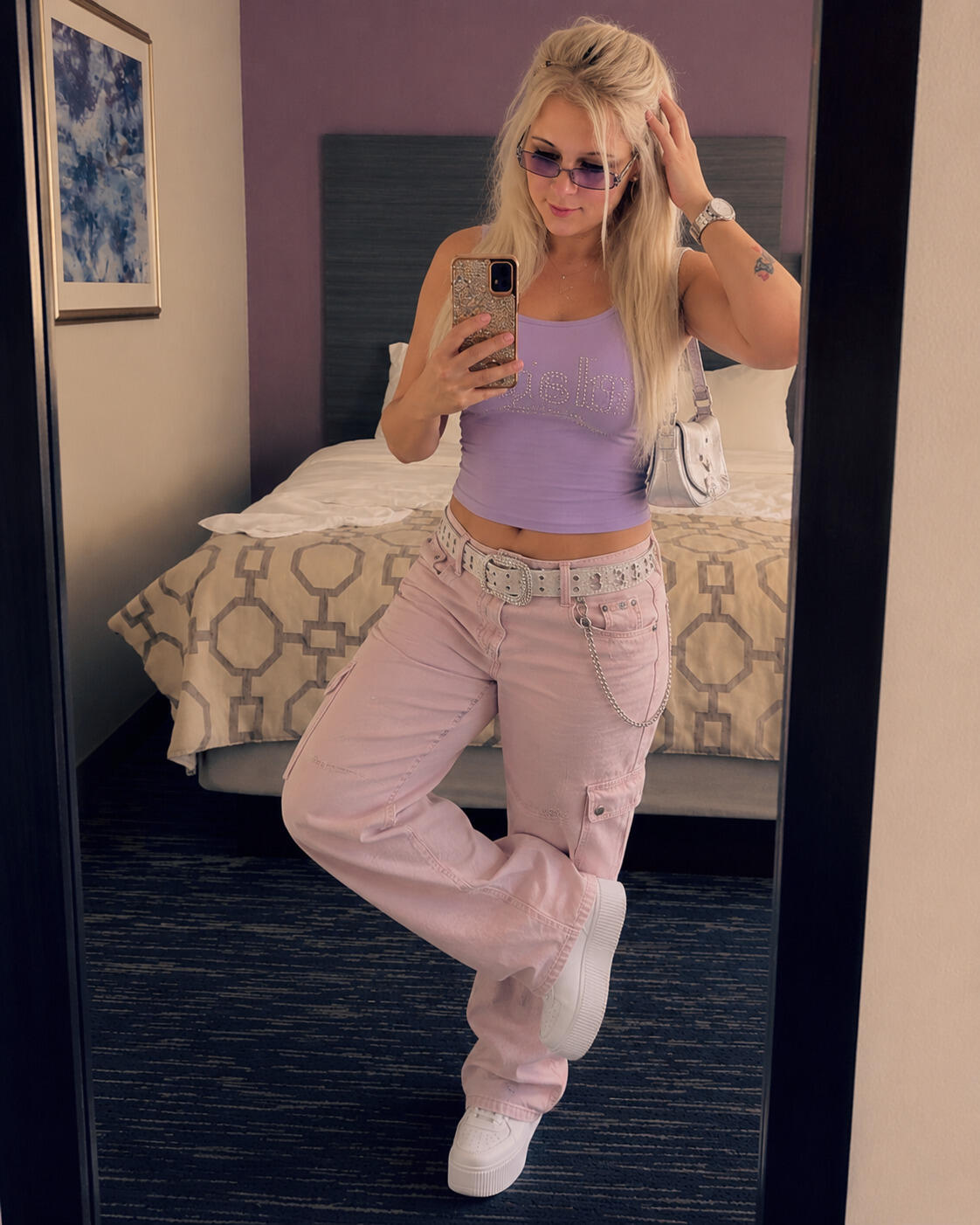 Woman posing in the mirror of a hotel room in a GEN Z Y2K outfit.