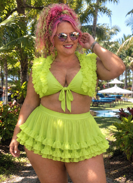 Woman in lime green ruffled swimsuit posing for picture at a resort.