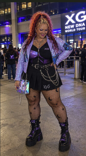 Woman wearing XG concert outfit ideas outside concert venue.